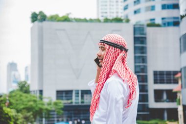 Akıllı telefon uygulaması kullanan İslami adam, ajandasını akıllı telefon Müslüman modern uae şehrine odaklıyor. Arap erkekleri tesettür ve Müslüman resmi giysileri giyer. Çevrimiçi yaşam tarzı mesajları gönderir.