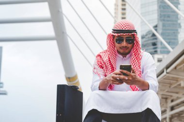 Akıllı telefon uygulaması kullanan İslami adam, ajandasını akıllı telefon Müslüman modern uae şehrine odaklıyor. Arap erkekleri tesettür ve Müslüman resmi giysileri giyer. Çevrimiçi yaşam tarzı mesajları gönderir.