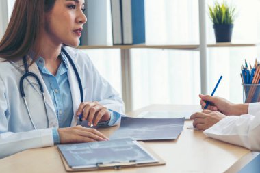 İki Asyalı kadın doktor, doktorun muayenehanesinde röntgen filmi danışmanlığı yapan hastalarla görüşmeyi tartışıyor. Asya tıp laboratuarındaki genç kadınlar birlikte sağlık hizmetleri hakkında konuşuyorlar.