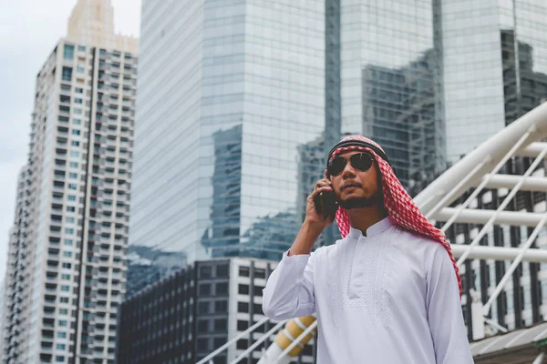 Akıllı telefon uygulaması kullanan İslami adam, ajandasını akıllı telefon Müslüman modern uae şehrine odaklıyor. Arap erkekleri tesettür ve Müslüman resmi giysileri giyer. Çevrimiçi yaşam tarzı mesajları gönderir.