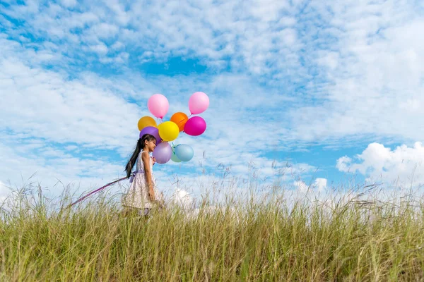 Vrolijk Schattig Meisje Houden Ballonnen Lopen Groene Weide Witte Wolk — Stockfoto