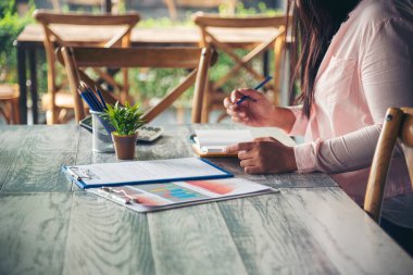İşletme masasında çalışan bir kadın evdeki dizüstü bilgisayarla çalışıyor. İş kadını finansal iş haritası, grafik, bilgi analizi satış istatistiklerini inceliyor. Kadın ellerini girişimci bürosunun masasına koydu