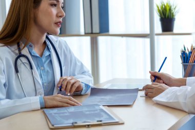 İki Asyalı kadın doktor, doktorun muayenehanesinde röntgen filmi danışmanlığı yapan hastalarla görüşmeyi tartışıyor. Asya tıp laboratuarındaki genç kadınlar birlikte sağlık hizmetleri hakkında konuşuyorlar.