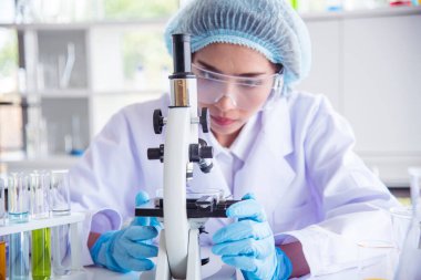Laboratuvardaki kadın bilim adamı mikroskop tıbbi testine ve biyoloji kimyasına bakıyor. Bilimsel eczane genetik araştırmalarını analiz eden kadın teknisyen laboratuarı. Kimya Tıp Laboratuvarı
