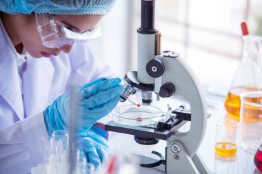 Laboratuvardaki kadın bilim adamı mikroskop tıbbi testine ve biyoloji kimyasına bakıyor. Bilimsel eczane genetik araştırmalarını analiz eden kadın teknisyen laboratuarı. Kimya Tıp Laboratuvarı