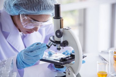 Laboratuvardaki kadın bilim adamı mikroskop tıbbi testine ve biyoloji kimyasına bakıyor. Bilimsel eczane genetik araştırmalarını analiz eden kadın teknisyen laboratuarı. Kimya Tıp Laboratuvarı