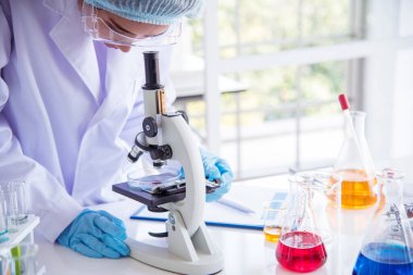 Laboratuvardaki kadın bilim adamı mikroskop tıbbi testine ve biyoloji kimyasına bakıyor. Bilimsel eczane genetik araştırmalarını analiz eden kadın teknisyen laboratuarı. Kimya Tıp Laboratuvarı