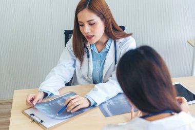 İki Asyalı kadın doktor, doktorun muayenehanesinde röntgen filmi danışmanlığı yapan hastalarla görüşmeyi tartışıyor. Asya tıp laboratuarındaki genç kadınlar birlikte sağlık hizmetleri hakkında konuşuyorlar.