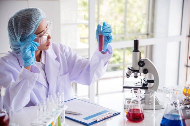 Laboratuvardaki kadın bilim adamı mikroskop tıbbi testine ve biyoloji kimyasına bakıyor. Bilimsel eczane genetik araştırmalarını analiz eden kadın teknisyen laboratuarı. Kimya Tıp Laboratuvarı