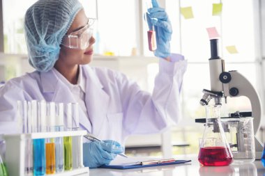 Laboratuvardaki kadın bilim adamı mikroskop tıbbi testine ve biyoloji kimyasına bakıyor. Bilimsel eczane genetik araştırmalarını analiz eden kadın teknisyen laboratuarı. Kimya Tıp Laboratuvarı