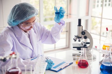 Laboratuvardaki kadın bilim adamı mikroskop tıbbi testine ve biyoloji kimyasına bakıyor. Bilimsel eczane genetik araştırmalarını analiz eden kadın teknisyen laboratuarı. Kimya Tıp Laboratuvarı
