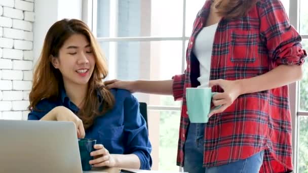 在工作中 亚洲同事的友谊面带微笑 快乐的两位女同事一起在办公室桌上开会 与计算机膝上型计算机启动公司合作的团队业务伙伴 — 图库视频影像