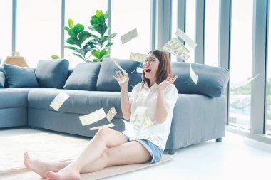 Elinde dolar olan mutlu Asyalı kadın mutluluğu kutluyor zenginliği kutluyor piyango parası yağmur damlası. Kazanan iş kadını para akışı yapar gülen surat