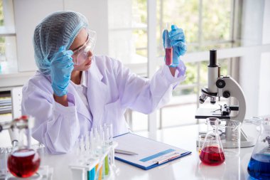 Laboratuvardaki kadın bilim adamı mikroskop tıbbi testine ve biyoloji kimyasına bakıyor. Bilimsel eczane genetik araştırmalarını analiz eden kadın teknisyen laboratuarı. Kimya Tıp Laboratuvarı