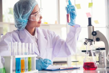 Laboratuvardaki kadın bilim adamı mikroskop tıbbi testine ve biyoloji kimyasına bakıyor. Bilimsel eczane genetik araştırmalarını analiz eden kadın teknisyen laboratuarı. Kimya Tıp Laboratuvarı