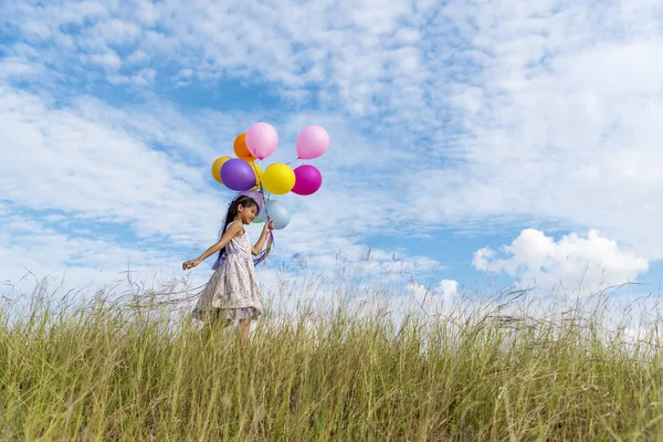 Wesoły Cute Girl Gospodarstwa Balony Działa Zielonej Łące Białej Chmury — Zdjęcie stockowe