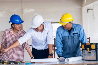İnşaat mühendisi takım çalışması güvenlik ekibi, inşaat sahasında beyaz sarı şapkalı güvenlik ekipmanı tutuyor. Hardhat İnşaat Mühendisliği Mühendisliği Yöneticisini Koru