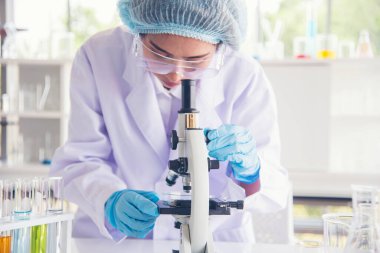 Laboratuvardaki kadın bilim adamı mikroskop tıbbi testine ve biyoloji kimyasına bakıyor. Bilimsel eczane genetik araştırmalarını analiz eden kadın teknisyen laboratuarı. Kimya Tıp Laboratuvarı