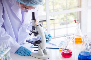 Laboratuvardaki kadın bilim adamı mikroskop tıbbi testine ve biyoloji kimyasına bakıyor. Bilimsel eczane genetik araştırmalarını analiz eden kadın teknisyen laboratuarı. Kimya Tıp Laboratuvarı