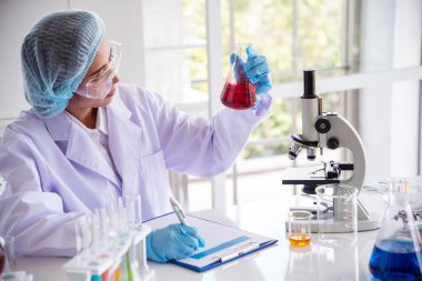 Laboratuvardaki kadın bilim adamı mikroskop tıbbi testine ve biyoloji kimyasına bakıyor. Bilimsel eczane genetik araştırmalarını analiz eden kadın teknisyen laboratuarı. Kimya Tıp Laboratuvarı