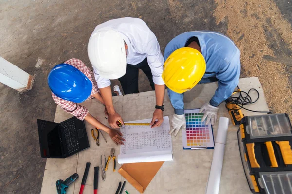 Construction engineer teamwork Safety Suit Trust Team Holding White Yellow Safety hard hat Security Equipment on Construction Site. Hardhat Protect Head for Civil Construction Engineer Concept