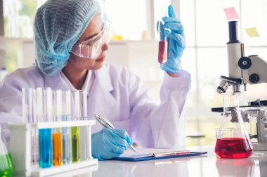 Laboratuvardaki kadın bilim adamı mikroskop tıbbi testine ve biyoloji kimyasına bakıyor. Bilimsel eczane genetik araştırmalarını analiz eden kadın teknisyen laboratuarı. Kimya Tıp Laboratuvarı