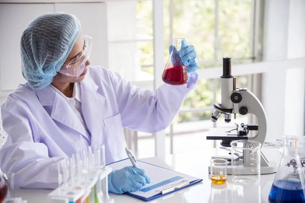Laboratuvardaki kadın bilim adamı mikroskop tıbbi testine ve biyoloji kimyasına bakıyor. Bilimsel eczane genetik araştırmalarını analiz eden kadın teknisyen laboratuarı. Kimya Tıp Laboratuvarı