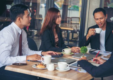 Bir grup iş adamı konferans odasında toplantı yapıyor. İşletme doküman grafiği ofis masasına danışmak için beyin fırtınası yapıyorlar. Çeşitli etnik gruplardan iş adamları beyin fırtınası yapıyor ve birlikte çalışıyorlar..