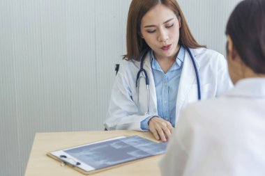 İki Asyalı kadın doktor, doktorun muayenehanesinde röntgen filmi danışmanlığı yapan hastalarla görüşmeyi tartışıyor. Asya tıp laboratuarındaki genç kadınlar birlikte sağlık hizmetleri hakkında konuşuyorlar.