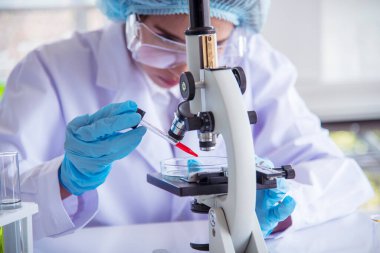Laboratuvardaki kadın bilim adamı mikroskop tıbbi testine ve biyoloji kimyasına bakıyor. Bilimsel eczane genetik araştırmalarını analiz eden kadın teknisyen laboratuarı. Kimya Tıp Laboratuvarı