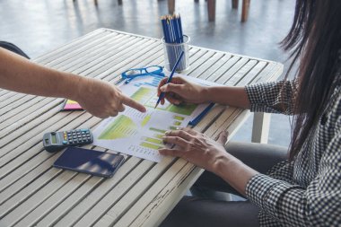 İşletme masasında çalışan bir kadın evdeki dizüstü bilgisayarla çalışıyor. İş kadını finansal iş haritası, grafik, bilgi analizi satış istatistiklerini inceliyor. Kadın ellerini girişimci bürosunun masasına koydu