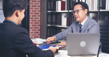 İki İşadamı sözleşme imzalarken iş anlaşması imzaladı. Takım çalışması. Yakın el ele tutuşun genç meslektaşlar birleşme ve satın alma işleriyle tanışın. Ortaklar Ofiste İmza Belgesi.