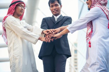 Çok ırklı Mutlu Ortaklar el ele tutuşuyor. Çok ırklı tebessüm grubundan insanlar el ele verip el ele tutuşuyorlar. Güçlendirme ortaklık ekiplerine katılan çeşitli insanlar gönüllü bağlantı kuruyor