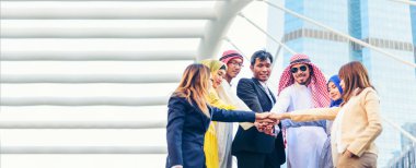 Banner Happy Diversity Takımları modern şehirde el ele tutuşan çok ırklı Ortaklar. Çok ırklı, kendine güveni olan mutlu insanlardan oluşan Panorama Ekibi açık havada güven takımlarına katılıyor.