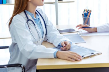 İki Asyalı kadın doktor, doktorun muayenehanesinde röntgen filmi danışmanlığı yapan hastalarla görüşmeyi tartışıyor. Asya tıp laboratuarındaki genç kadınlar birlikte sağlık hizmetleri hakkında konuşuyorlar.