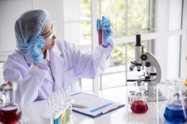 Kapalı alan kadın bilim adamı laboratuvarda düşürücü kullanıyor. Bilimsel mikroskop tıbbi testi, biyoloji kimyası araştırması. Kadın teknisyen laboratuarı kan bilimsel ilaç araştırmalarını inceliyor..