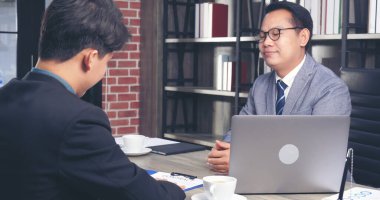 İki İşadamı sözleşme imzalarken iş anlaşması imzaladı. Takım çalışması. Yakın el ele tutuşun genç meslektaşlar birleşme ve satın alma işleriyle tanışın. Ortaklar Ofiste İmza Belgesi.