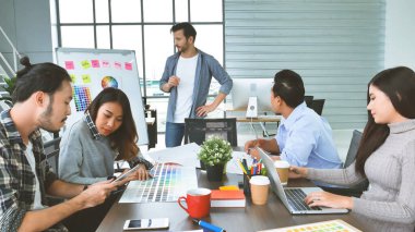 Çok ırklı iş adamlarından oluşan bir grup konferans salonunda iş dünyası grafiği ve grafiği üzerinde fikir alışverişinde bulunuyor. Çok Kültürlü Takım Çalışması, iş ortakları ve güven ortakları bir araya gelecek.