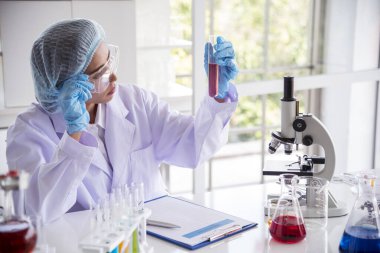 Laboratuvardaki kadın bilim adamı mikroskop tıbbi testine ve biyoloji kimyasına bakıyor. Bilimsel eczane genetik araştırmalarını analiz eden kadın teknisyen laboratuarı. Kimya Tıp Laboratuvarı
