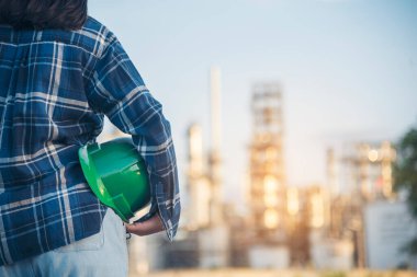 Yeşil şapkalı kadın mühendis güvenlik görevlisi ya da müfettiş. Çevresel sürdürülebilir işçi elleri sıkı yeşil iş kaskı mühendisliğini tutuyor. Kadın Yeşil iş ekosistem çevre mühendisliği