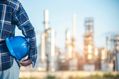 Elektrikçi, teknik operatör, mavi şapkalı, iş kaskı mühendisi. Mavi kasketi tutan mühendis kadın. Elektrikçi kadın işçi petrol endüstrisi güvenliği mavi işçi kaskında.