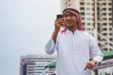 Akıllı telefon uygulaması kullanan İslami adam, ajandasını akıllı telefon Müslüman modern uae şehrine odaklıyor. Arap erkekleri tesettür ve Müslüman resmi giysileri giyer. Çevrimiçi yaşam tarzı mesajları gönderir.