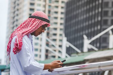 Akıllı telefon uygulaması kullanan İslami adam, ajandasını akıllı telefon Müslüman modern uae şehrine odaklıyor. Arap erkekleri tesettür ve Müslüman resmi giysileri giyer. Çevrimiçi yaşam tarzı mesajları gönderir.