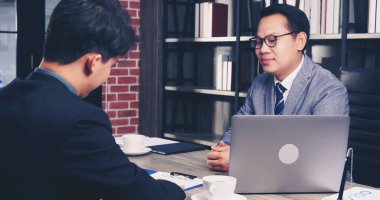 İki İşadamı sözleşme imzalarken iş anlaşması imzaladı. Takım çalışması. Yakın el ele tutuşun genç meslektaşlar birleşme ve satın alma işleriyle tanışın. Ortaklar Ofiste İmza Belgesi.