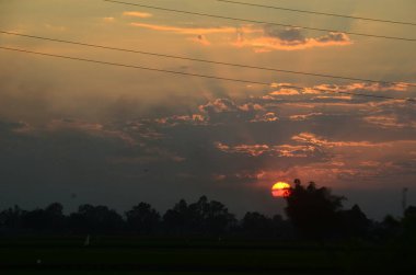 Manzarası dramatik güzel gün batımı gökyüzü. Doğal Günbatımı Karanlık Diyar 'ın gölgesinde. Kırsal kesimde gün batımında, şafakta, gün doğumunda canlı, dramatik bir gökyüzü. Gün batımında manzara Renkli Gökyüzü