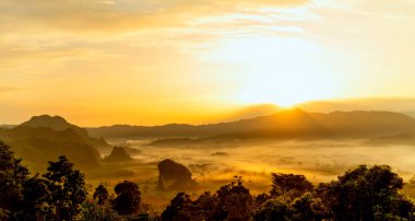 Gün batımı sıradağları güzel manzara sisli gündoğumu ışınları. Altın gökyüzü dağı manzarası sisli rüzgarlı dağ. Güneşin doğuşunda inanılmaz manzara bulutları. Kırsalda altın güneş ışığı cenneti manzarası