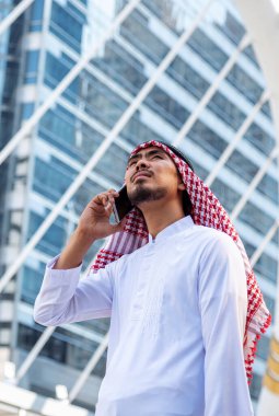 Portreli İslami İslamcı adam akıllı telefon uygulama takvimi kullanıyor. Güncel müslüman el ele tutuşmaya odaklanıyor. Dikey ufuk çizgisi olan Arap erkekleri başörtüsü takıyor.