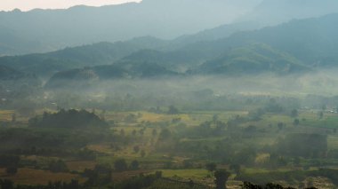 Dağ manzarasında dramatik bir gün batımı. Güzel manzara sisli tepeler alacakaranlık vakti. Mavi altın gökyüzü gün doğumu dramatik manzara dağları. Şafak vakti altın rengi alacakaranlık zamanı güneş ışığıyla bulutlu manzara