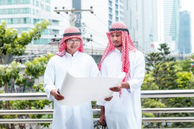 Arap Müslüman erkekler takım çalışanları olarak birlikte konuşuyorlar. Dijital pazarlama Arap grubu modern müslüman BAE şehrine danışmayı tartışıyor. Mutlu Girişimci Asyalı insanlar toplanan gülümseyen takımlar