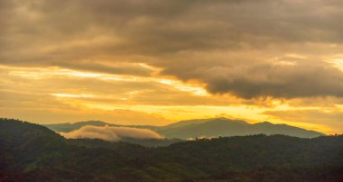 Gün batımı sıradağları güzel manzara sisli gündoğumu ışınları. Altın gökyüzü dağı manzarası sisli rüzgarlı dağ. Güneşin doğuşunda inanılmaz manzara bulutları. Kırsalda altın güneş ışığı cenneti manzarası